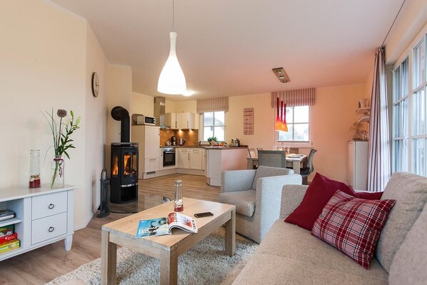 Una sala de estar acogedora con chimenea, un comedor y una cocina.