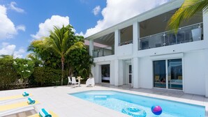 A modern house with a swimming pool, outdoor seating, and a balcony. - Blue Sailing | Ocean View - Located in  Wonderful Happy Bay with Private Pool (Saint Martin)