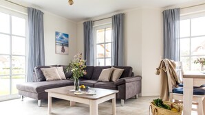 Un salon moderne avec un canapé gris, une table basse et un panier en osier.