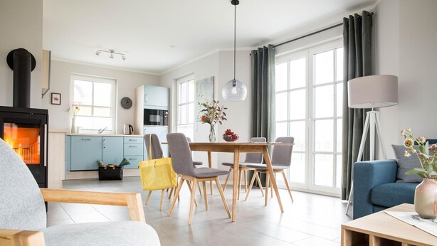 Un salon moderne avec une cheminée, un coin repas et un canapé.