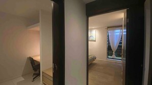 A room with a bed, a desk, and a chair. There is a window with curtains. - Peaceful Home (Desamparados)