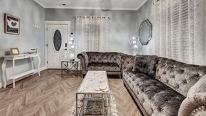 A living room with a sectional sofa, a coffee table, a white console table, and a door with a decorative mirror. - 💎Urban Glam Gem💎 Rancher near Gonzaga w/GiG Internet (Spokane)