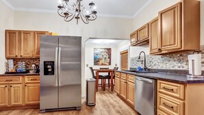 A modern kitchen with wooden cabinets, stainless steel appliances, and a tiled backsplash. - 💎Urban Glam Gem💎 Rancher near Gonzaga w/GiG Internet (Spokane)