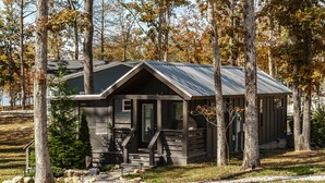 A cabin with a sloped roof, a front porch, and a small deck. - Heavensent Tiny Home @ The Retreat at Water's Edge - Lake Views! (Tracy City)