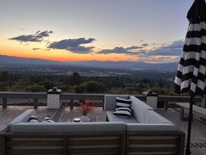 An outdoor seating area with a view of a cityscape at sunset. - 🏔Views for Days! Welcome to the Missoula Lookout! 🏔 (Missoula)