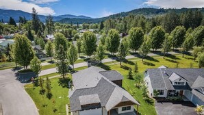 A residential area with houses featuring sloped roofs, well-maintained lawns, and a mountainous backdrop. - Family Home | Marina, Dover Bay | Extended Stays (Dover)