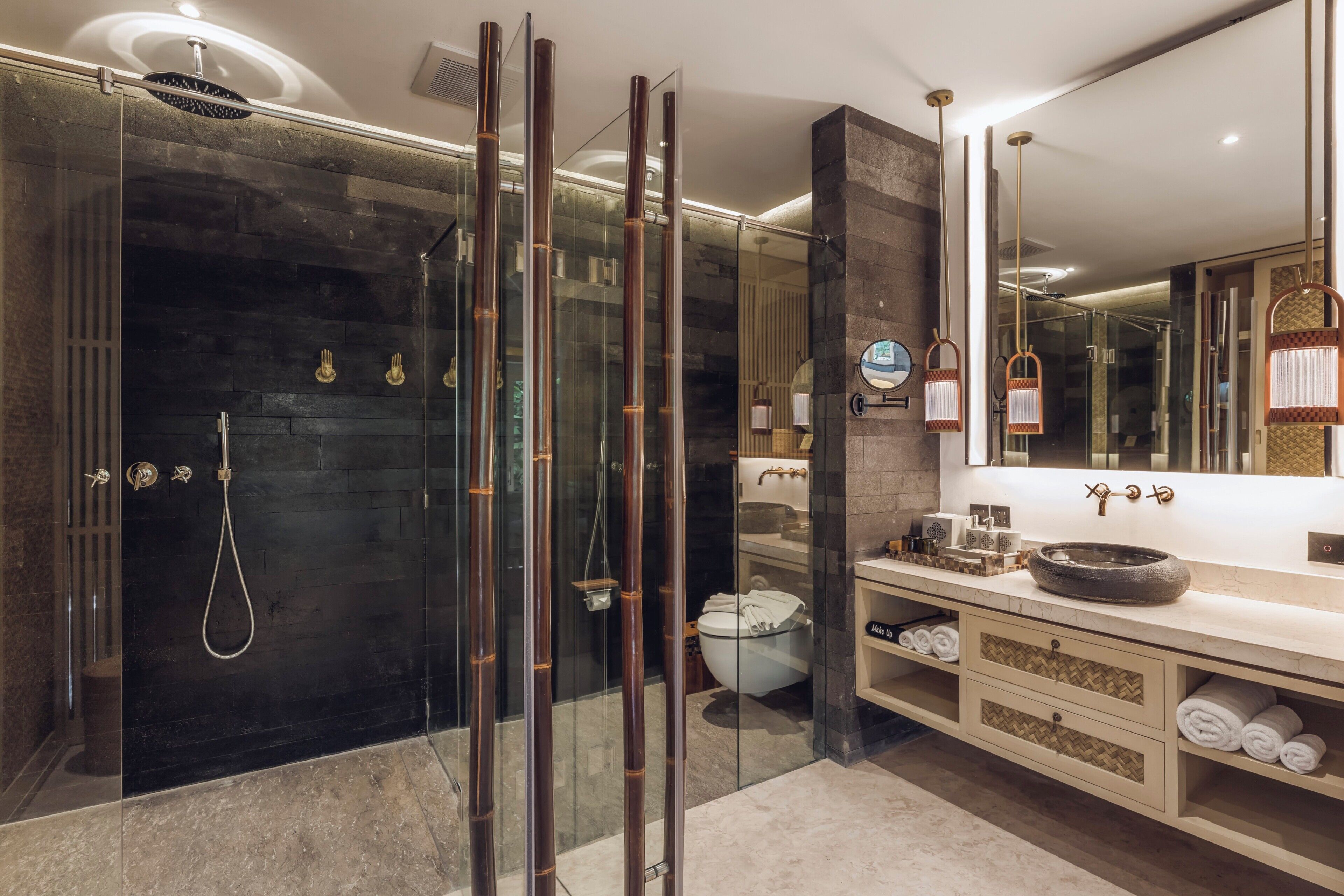 A modern bathroom with a glass-enclosed shower, a large mirror, and a vanity with a bowl sink.