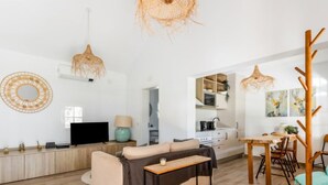 A modern living room with a sofa, a coffee table, and a dining area with chairs. - Quinta de Santa Emilia 1 by Interhome (Alcácer do Sal)