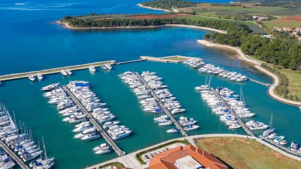 An aerial view of a marina with numerous boats docked, surrounded by a coastal landscape and a clear sky. - Altalune by Interhome (Novigrad (Istra))