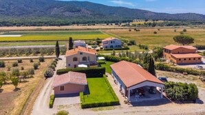 A rural property with multiple buildings, a well-maintained lawn, and surrounding agricultural fields.