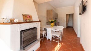A compact kitchen with a dining area, a fireplace, and a small table with chairs.