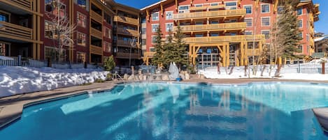Guests can enjoy a refreshing swim in the pool surrounded by a white fence.