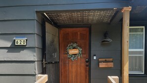 Una puerta principal de madera con un letrero de bienvenida, un buzón y el número 620.