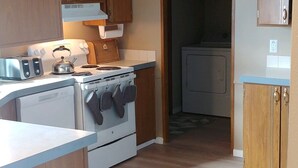 A kitchen with wooden cabinets, a stove, and a microwave.