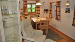 A cozy dining area with a wooden table, chairs, and a glass cabinet.