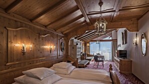 Een houten kamer met een bed, een bureau en een stoel.