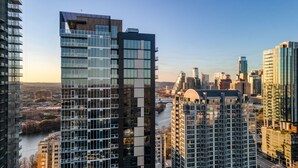 Un immeuble de grande hauteur doté d’une façade moderne en verre, entouré d’autres bâtiments imposants dans un paysage urbain.