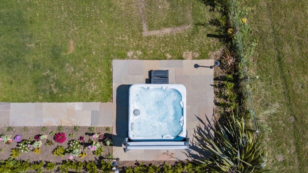 Ein Luftbild eines Whirlpools, umgeben von einem Garten mit verschiedenen Blumen und Pflanzen.