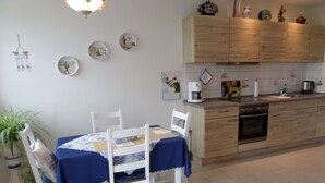 Een keuken met houten kastjes, een koffiezetapparaat en een spoelbak.