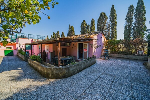 A small, single-story building with a tiled roof and a covered patio area.