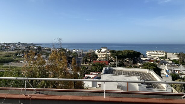 A coastal cityscape with buildings and a clear view of the sea.