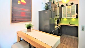Una cocina moderna con un banco de madera, un ventanal con vistas y una pared de acento verde.
