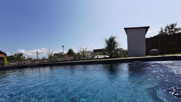 Una piscina limpida con vista sugli edifici e la vegetazione circostanti.