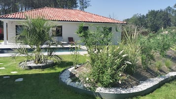 Enjoy a serene outdoor space with a garden, pool, and patio area.