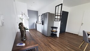 Una cucina moderna con pavimento in legno, un'area pranzo con una sedia e una statua sul bancone.