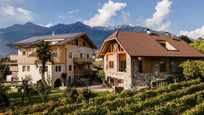 A hotel with a stone facade, wooden balconies, and a view of mountains. - Apartment 'Torgglbauer 1' with Mountain View, Pool, Terrace & Wi-Fi (Meran)