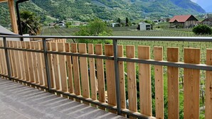 A wooden balcony with a view of a vineyard and mountains. - Holiday Apartment "Torgglbauer 2" with Mountain View, Pool, Terrace & Wi-Fi (Meran)