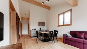Ein modernes Interieur mit Essbereich, Küche und einem roten Sofa.