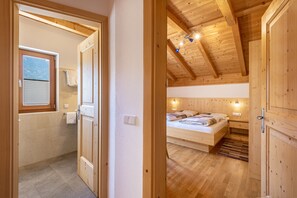 A wooden interior with a bed, a window, and a door. - Holiday Apartment 'Thusnelda C' with Mountain View, Balconies & Wi-Fi (Seis am Schlern)