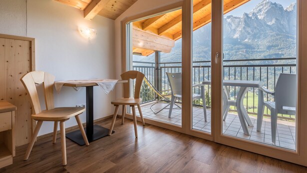 Un interior de madera con un balcón que da a montañas.
