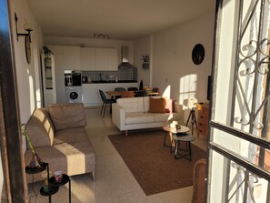 Ein Wohnzimmer mit einer Couch, einem Couchtisch und einem Essbereich mit Stühlen.