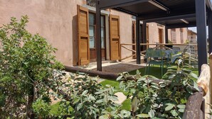 A building with a covered outdoor area, wooden doors, and a brick archway. - Studio Apartment "Pianosa" with Sea View, Garden, Wi-Fi & Shared Pool (Piombino)
