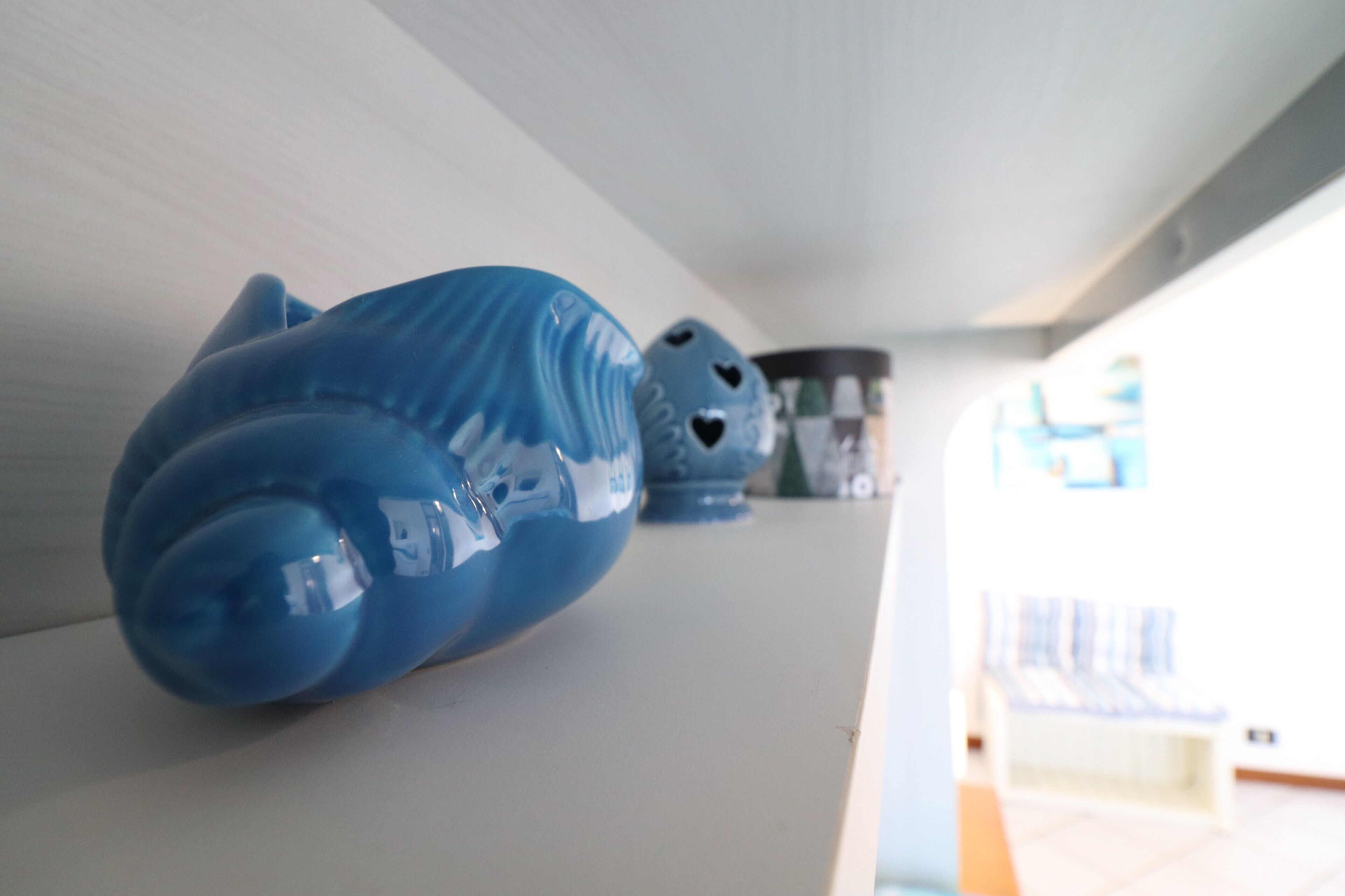 A row of blue ceramic objects on a shelf.