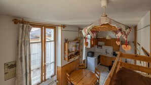 Een gezellige keuken met houten kastjes, een eettafel en een hanglamp.