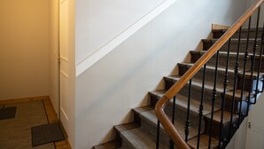 Een trap met houten leuningen en een bekleed landingsvlak.