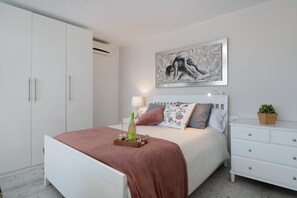 Une chambre à coucher avec un lit, une table de chevet, une lampe et un tableau au mur.