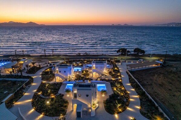 A coastal resort with multiple villas, a central courtyard, and a view of the sea at sunset. - Blue Pearls - Adults Only (Kos)