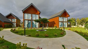 A modern building with large windows and a well-maintained lawn. - Villa d'Mare (Demre)