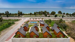 A resort with multiple wooden cabins, a swimming pool, and a view of the ocean. - Villa d'Mare (Demre)