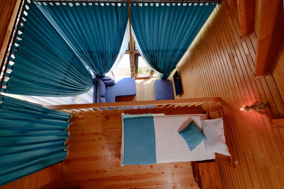 A room with a bed, a window, and curtains.