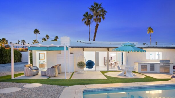 A modern house with a pool, outdoor seating, and a patio area.