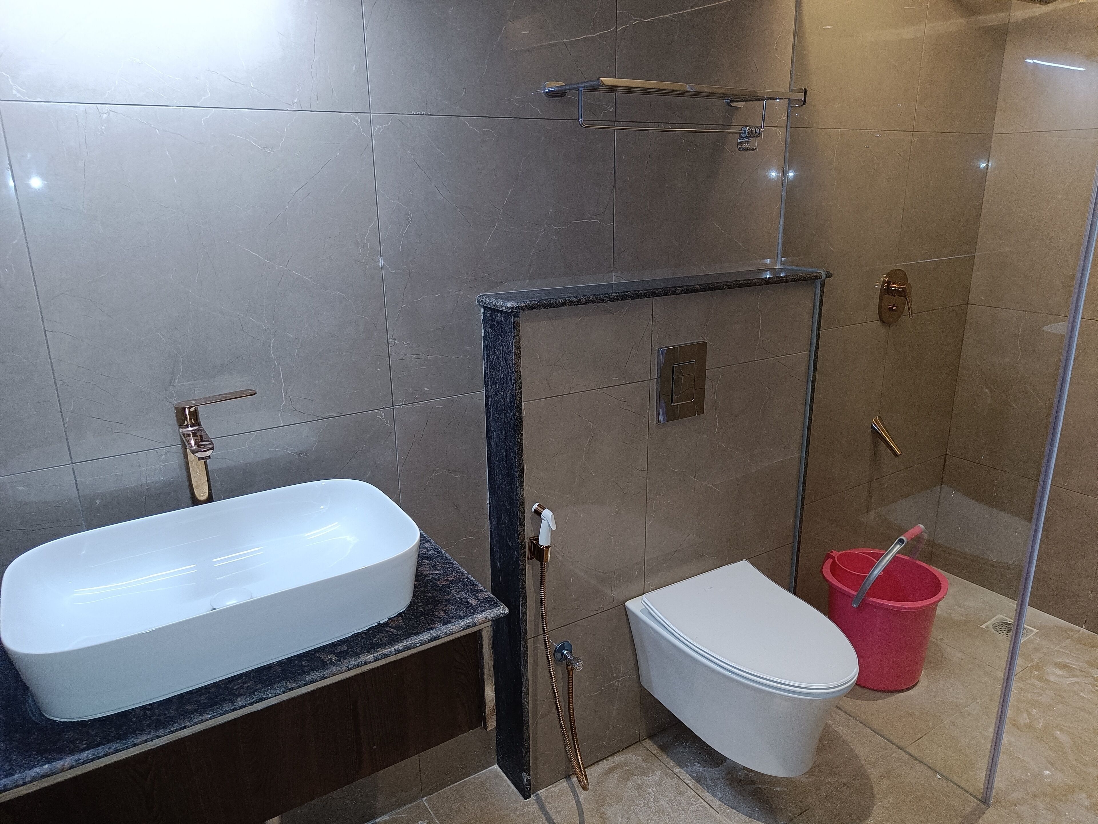Un baño moderno con lavamanos, inodoro y ducha blancos.