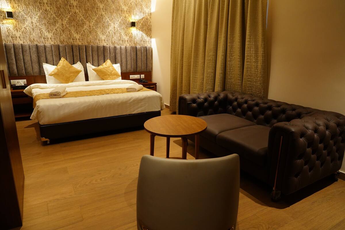 Ett hotellrum med en säng, en soffa, ett litet bord och ett nattduksbord.