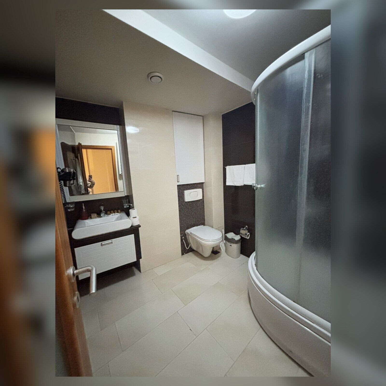 A modern bathroom with a sink, toilet, and shower.
