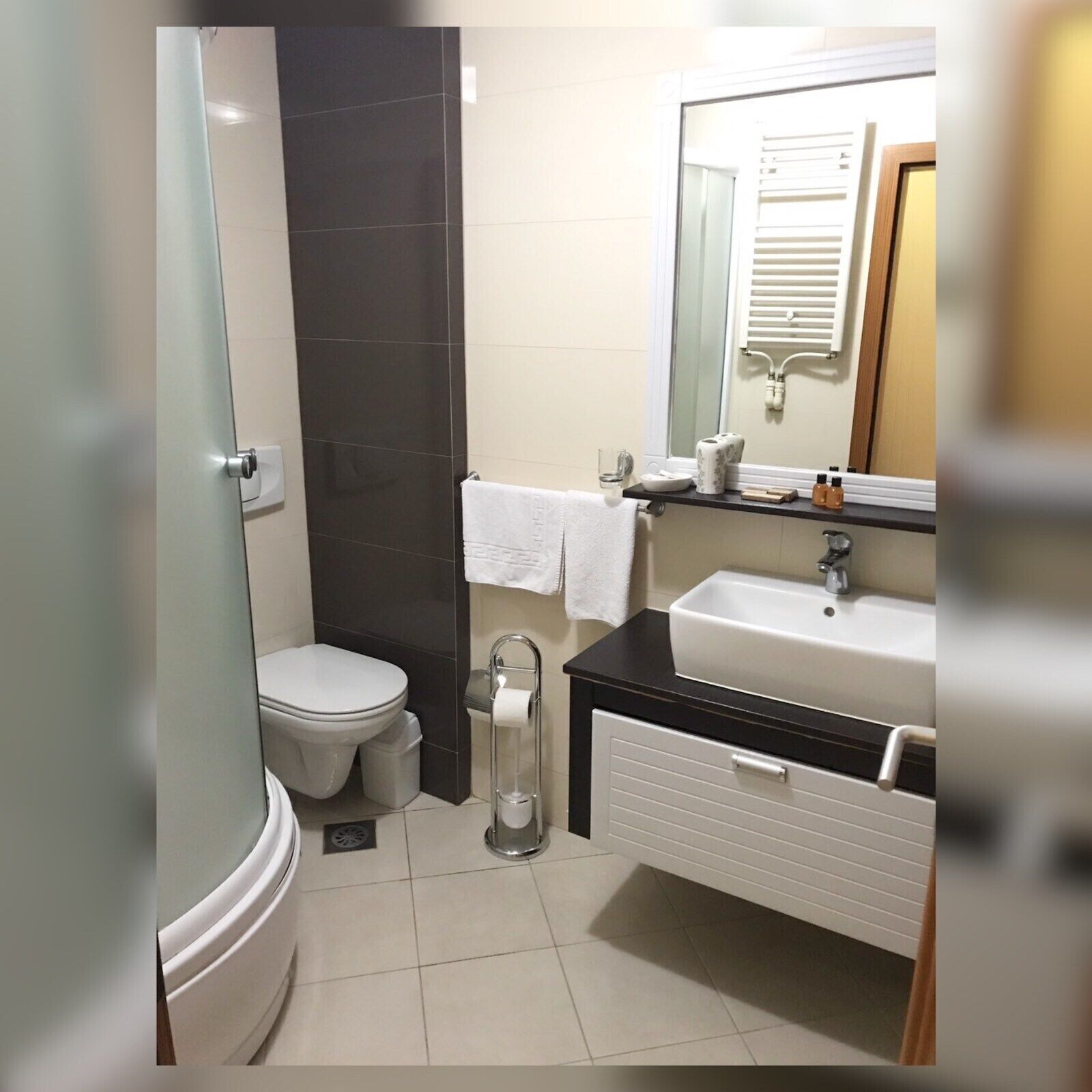 A compact bathroom with a toilet, a sink, and a shower area.