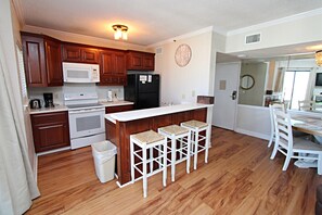 Enjoy cooking in this well-equipped kitchen with a stove, refrigerator, and sink.